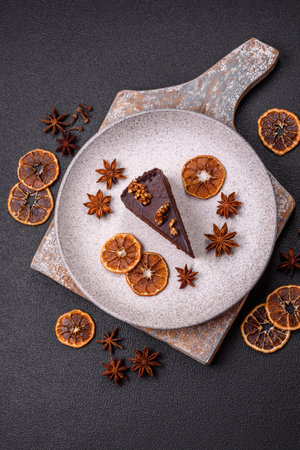 Piece of sweet chocolate cake with nuts on dark concrete backgroundの写真素材