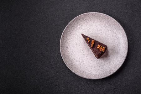 Piece of sweet chocolate cake with nuts on dark concrete backgroundの写真素材