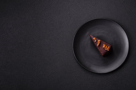 Piece of sweet chocolate cake with nuts on dark backgroundの写真素材