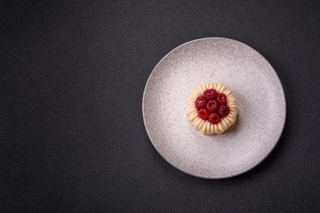 Sweet mousse tart with raspberries and filling on a dark concrete backgroundの写真素材
