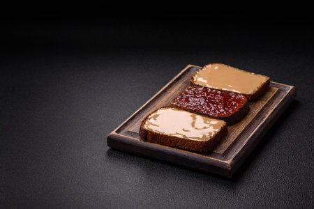 Sandwiches with toast bread, peanut butter and raspberry or strawberry jam. Hearty, nutritious breakfastの写真素材