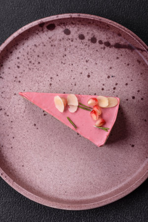 Piece of sweet cheesecake with pink cream cheese of raspberry or strawberry flavor on a dark textured backgroundの写真素材