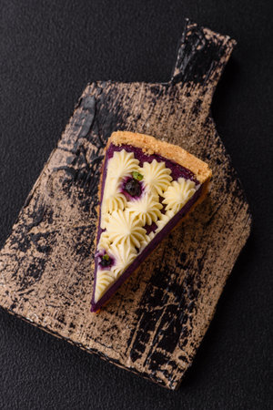 No baked sweet blueberry cheesecake with cream cheese on a dark texture backgroundの写真素材
