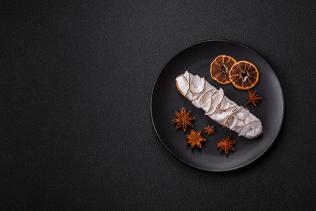 Sweet eclair decorated with coconut slices on a dark concrete background