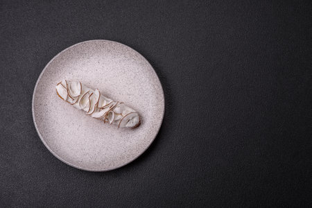 Sweet eclair with custard decorated with coconut slices on a dark concrete background