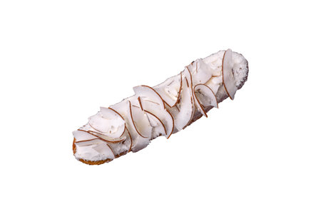 Sweet eclair with custard decorated with coconut slices on a white background
