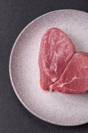 Raw steak with salt, spices and herbs prepared for grillingの写真素材