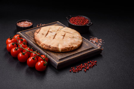 Round flatbread or pita with cheese, herbs, salt and spices, baked on the grillの写真素材