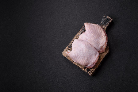 Raw chicken thighs with salt, spices and herbsの写真素材