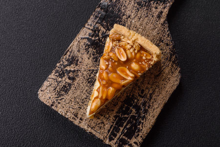 Delicious fresh cheesecake cake with cream and nuts on a ceramic plate on a dark concrete background