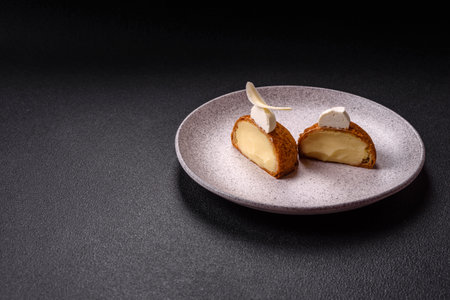 Delicious sweet shu cake with cream and nuts on a dark concrete backgroundの写真素材