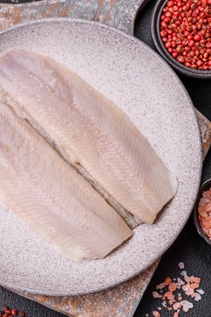 Herring fillet salted and marinated with salt, spices and oil on a dark concrete backgroundの写真素材