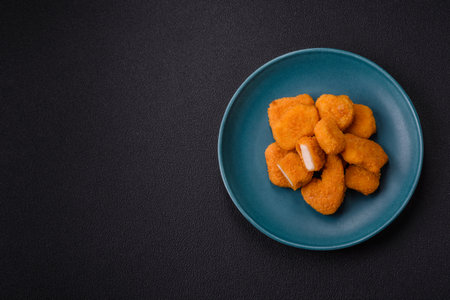 Delicious fresh crispy chicken nuggets on a dark concrete background. Unhealthy food, fast foodの写真素材