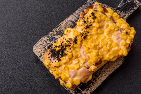 Sandwich with brioche, meat, melted cheese, corn, salt, spices and herbs on a dark concrete...