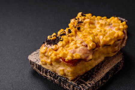 Sandwich with brioche, meat, melted cheese, corn, salt, spices and herbs on a dark concrete...