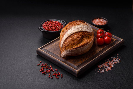 Homemade fresh crispy wholemeal bread on dark concrete background