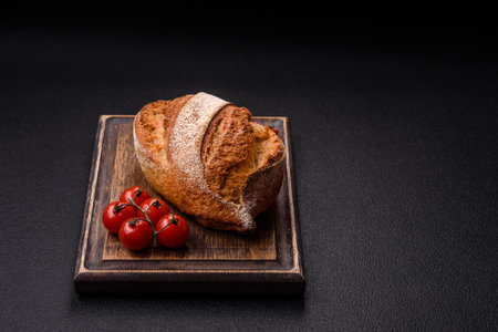Homemade fresh crispy wholemeal bread on dark concrete background