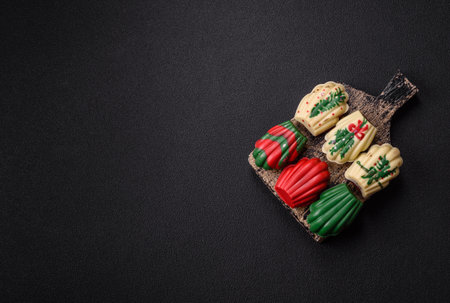 Sweet madeleine sponge cookies covered with colored chocolate in a Christmas styleの写真素材