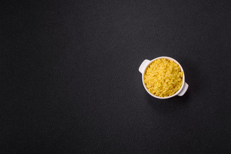 Arborio risotto rice with salt, spices and herbs on a dark concrete background