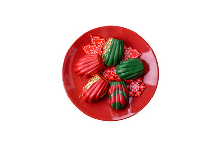 Sweet Madeleines desserts covered with chocolate in Christmas colors, with various toppings on a...
