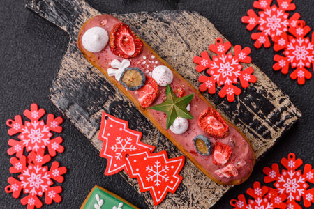 Sweet eclair with chocolate filling covered with red glaze, decorated for Christmas and New Year