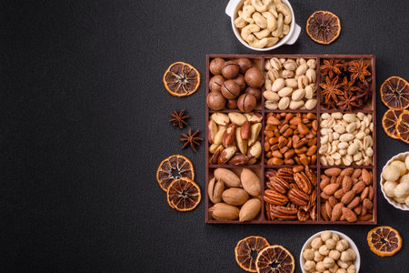 Box with various nuts cashew, macadamia, peanut, cedar, pecan, walnut, brazil, hazelnut on dark...