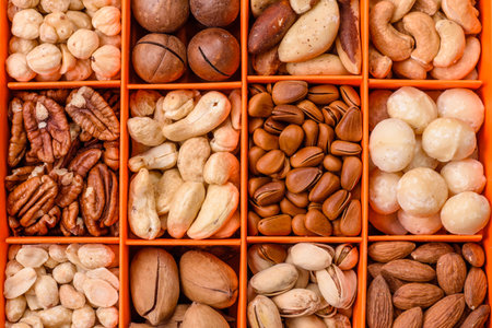 Box with various nuts cashew, macadamia, peanut, pecan, walnut, brazil, hazelnut on dark textured backgroundの写真素材