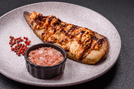 Grilled mackerel fillets with cheese, salt, spices and herbs on dark concrete backgroundの写真素材