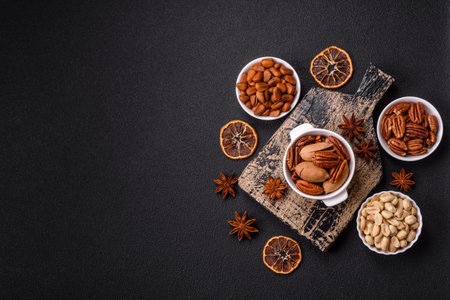 Delicious nutritious pecan nuts in ceramic bowl on dark concrete backgroundの写真素材