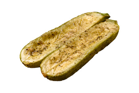 Delicious zucchini cut into two halves baked with salt, spices and herbs on a white backgroundの写真素材