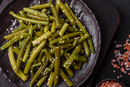 Steamed green beans on a plate with olive oil, sesame seeds, salt and spicesの写真素材