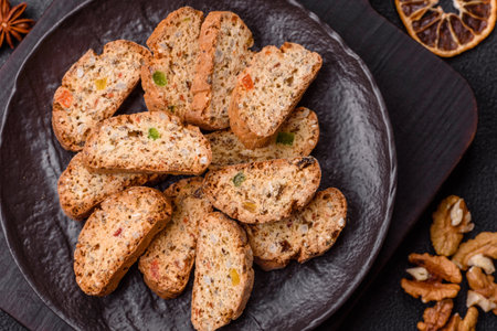 Freshly baked Italian cantuccini cookies with nuts and candied fruits on dark concrete backgroundの写真素材