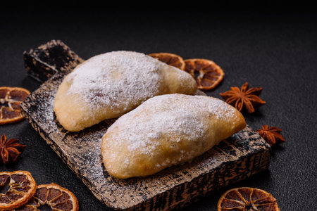 Sweet dumplings sprinkled with powdered sugar on dark concrete background