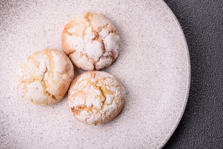 Delicious round freshly baked lemon flavored cookies on dark concrete background