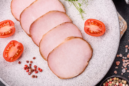 Meat, smoked, ham sliced with salt, spices and herbs on dark concrete background