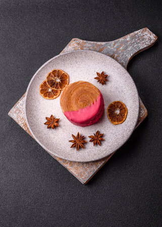 Round sweet roll croissant with raspberry cream filling on a dark concrete backgroundの写真素材