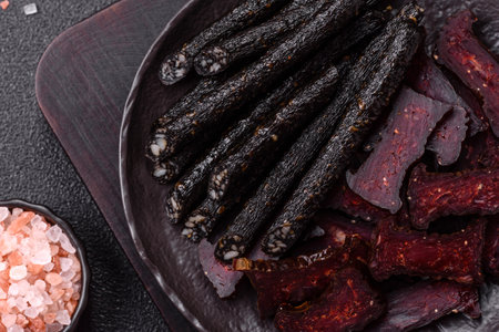 Sausage with salt, spices and herbs on a dark concrete backgroundの写真素材