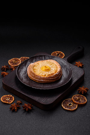 Sweet round tart with pineapple on a dark concrete backgroundの写真素材
