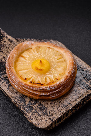 Sweet round tart with pineapple on a dark concrete backgroundの写真素材