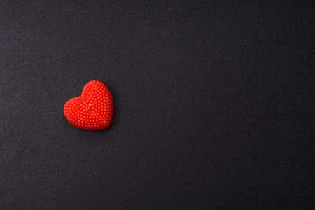 Red heart-shaped object on a dark concrete background
