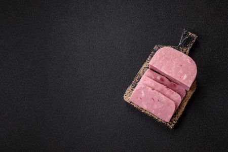 Delicious pink ham with salt, spices and herbs on a dark concrete backgroundの写真素材