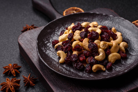 Mixture of roasted cashews and dried cranberries on a dark concrete backgroundの写真素材