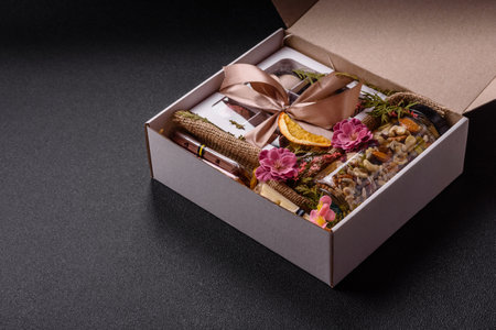 Gift box with a jar of nuts with honey, chocolate and craft candies made at homeの写真素材