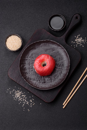 Donut shaped sushi roll with salmon on dark concrete backgroundの写真素材