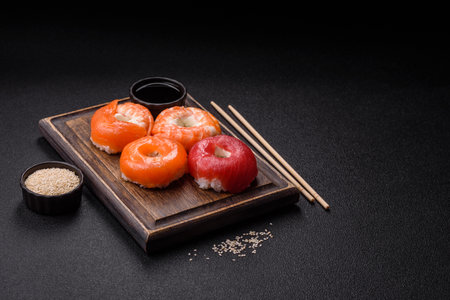 Donut shaped sushi rolls with salmon, shrimp and tuna on dark concrete backgroundの写真素材