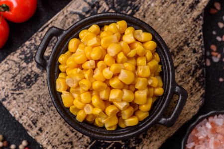 Sweet yellow canned corn in bowl on dark concrete backgroundの写真素材