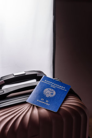 International passport of a citizen of North Korea on a suitcase, departure from the airport, international travelの写真素材