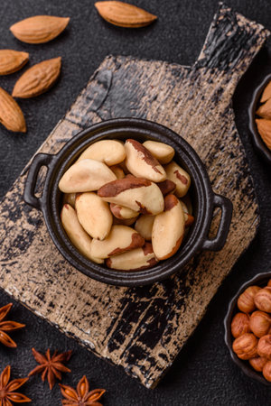 Brazil nut kernels in ceramic bowl on dark concrete background