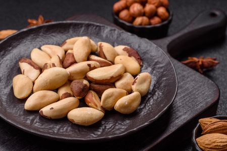 Brazil nut kernels in ceramic bowl on dark concrete backgroundの写真素材