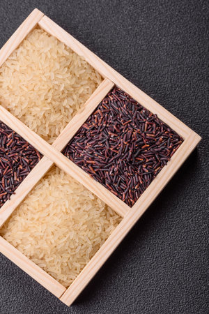 White and red raw rice grains in a wooden container.の写真素材